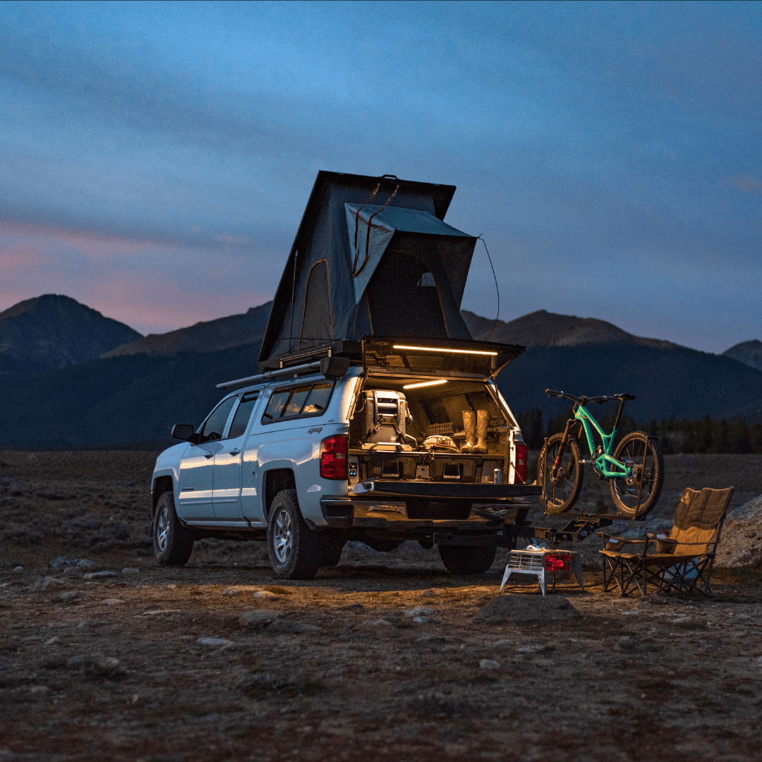 Kingpin truck bed camping mountain biking canopy camper shell in wilderness