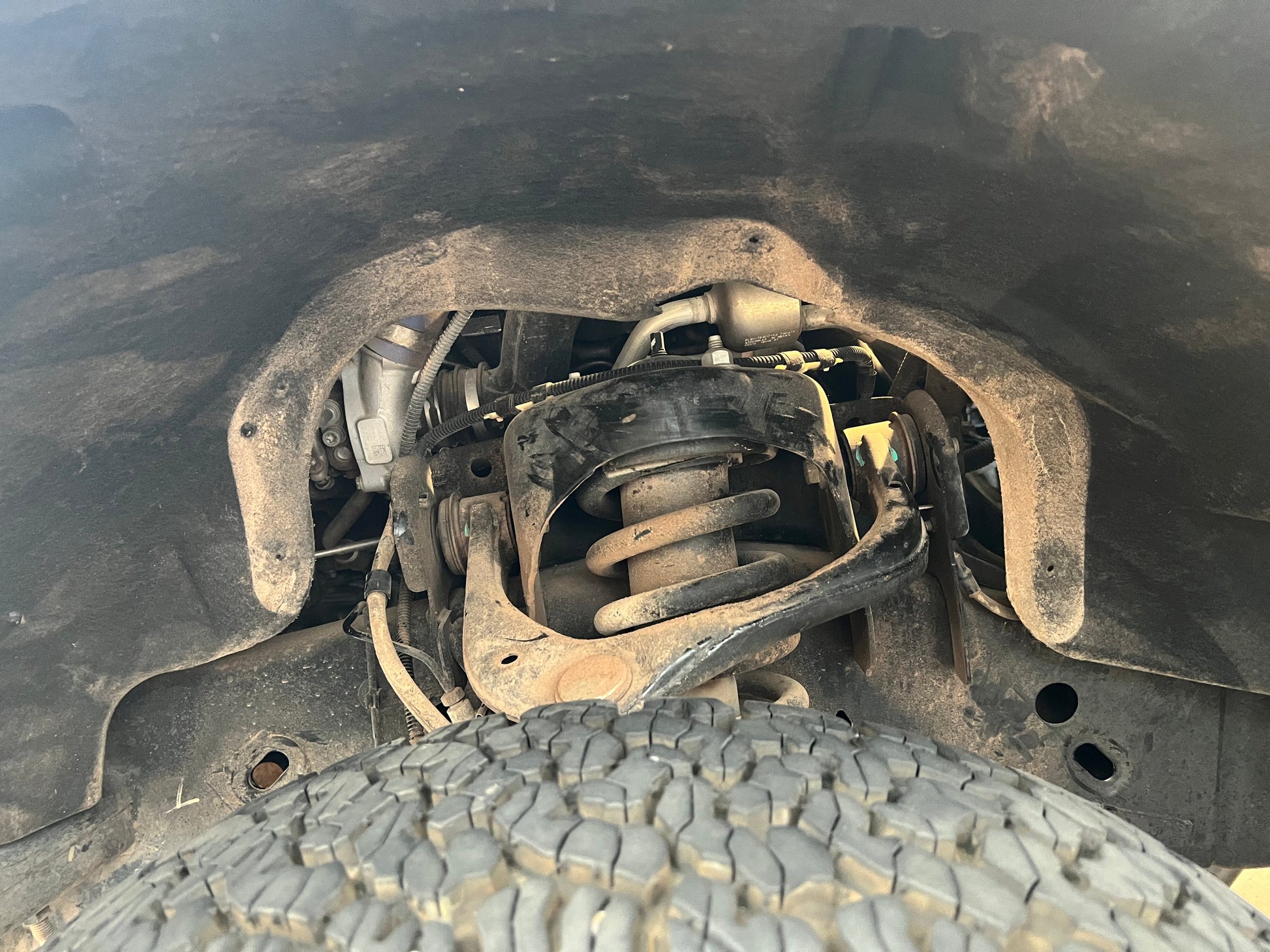 2015-2020 ford f 150 eco boost before having ark splash guards installed showing the opening to the engine bay between the fender liner and the body of the 2015-2020 ford f150 ecoboost and all the exposed components